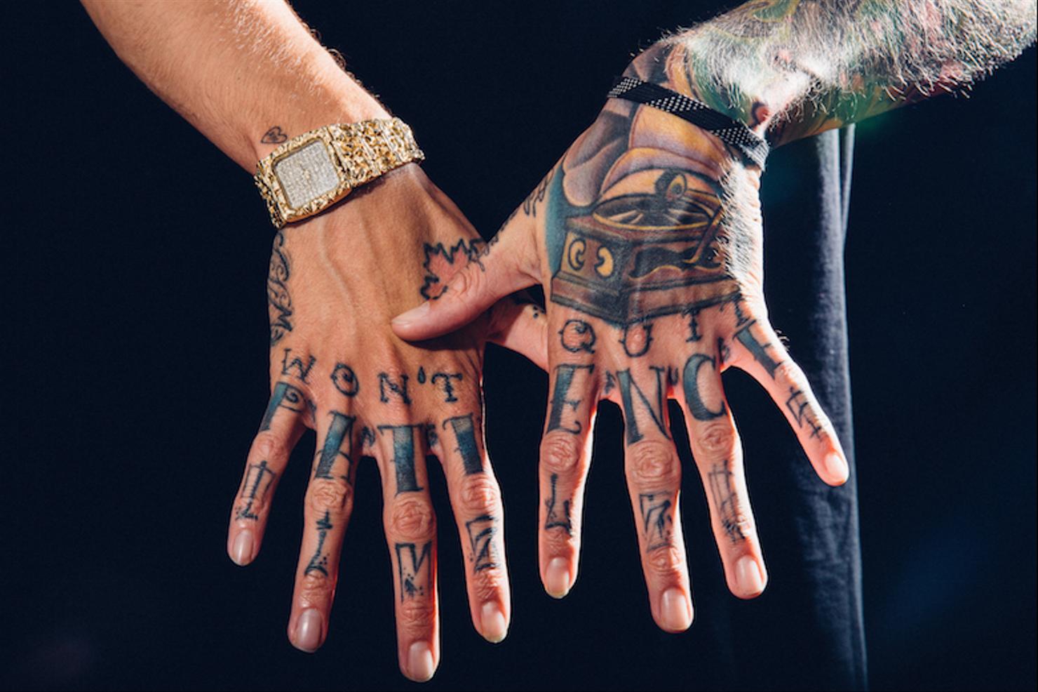 Travis Mills hand tattoos and lettering across both hands