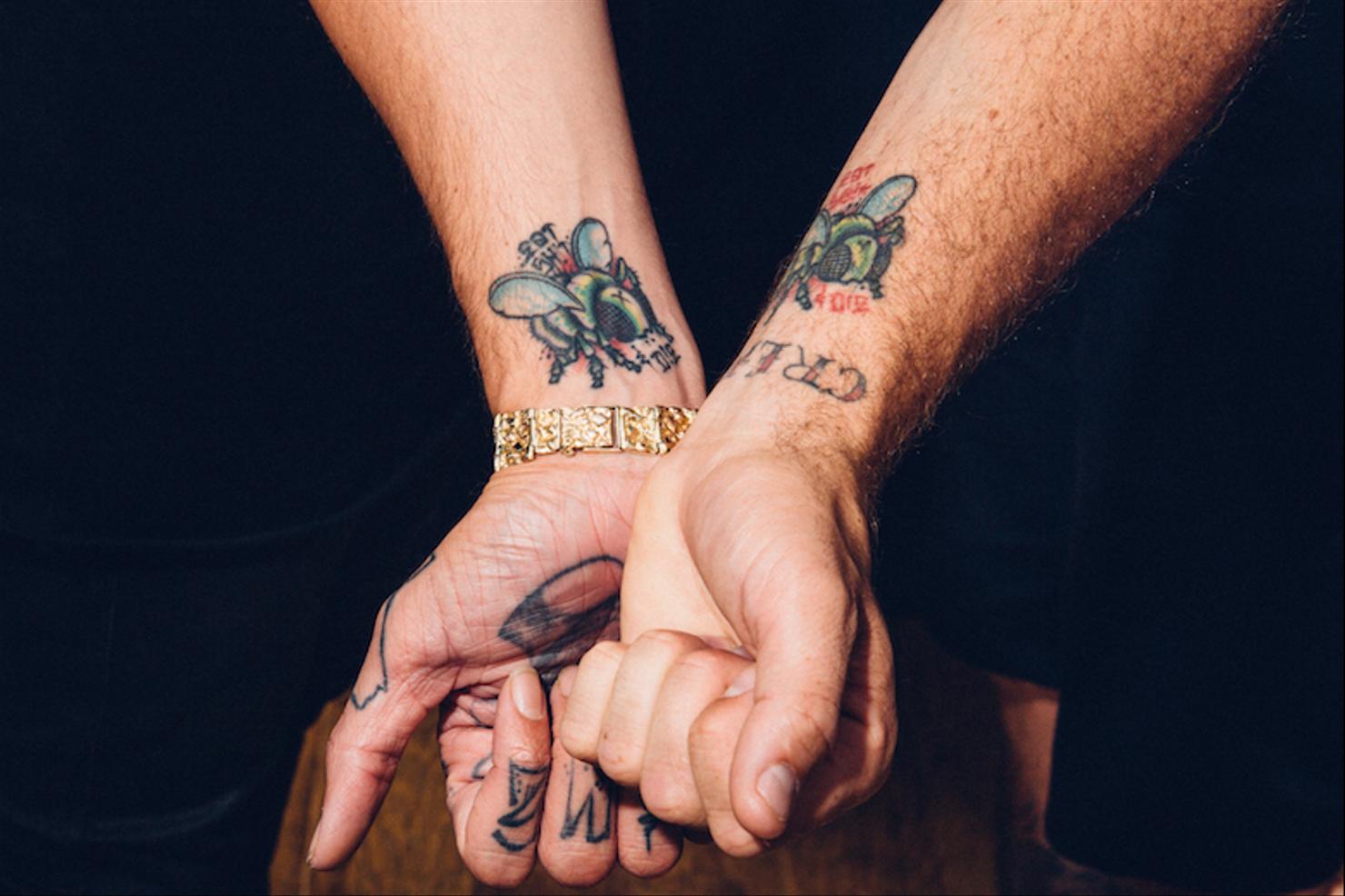Travis Mills black bitten apple palm tattoo and hand tattoos