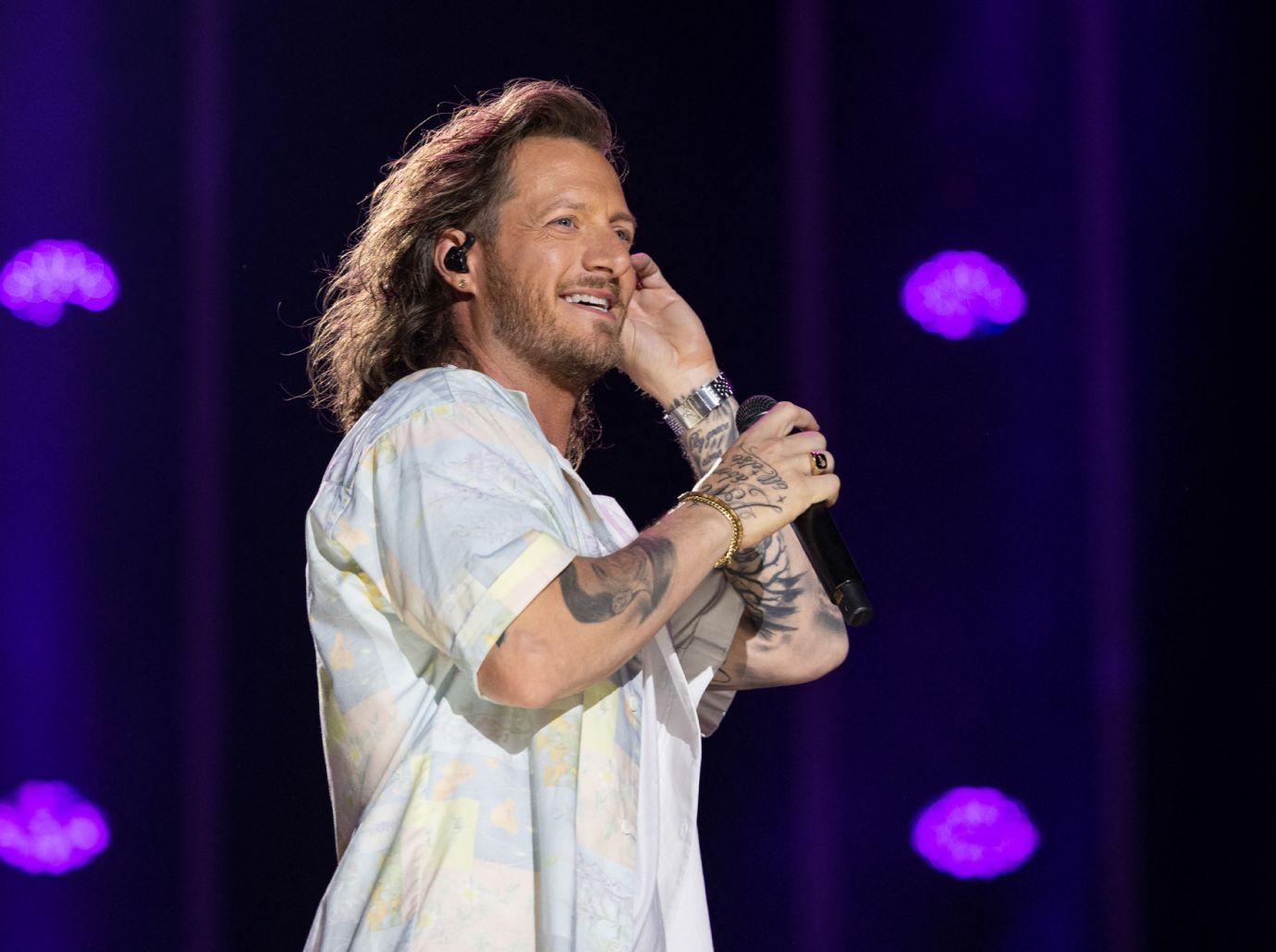 Tyler Hubbard tattoos: stage photograph showing Hubbard’s tattooed forearms