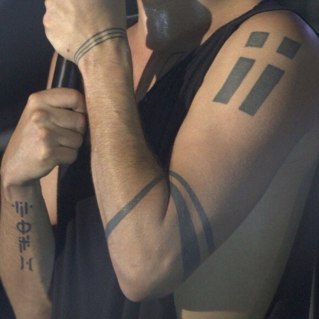 Tyler Joseph tattoos: shoulder and wrist shape tattoos