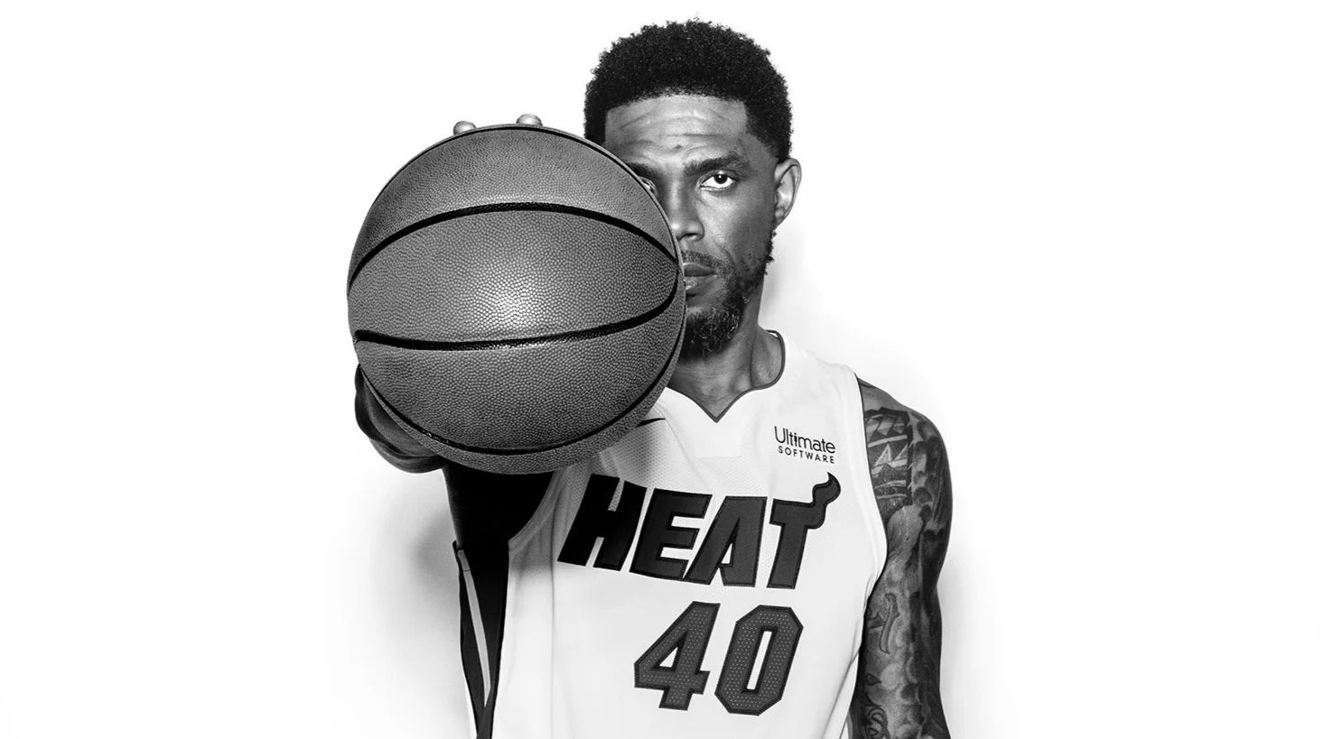 Udonis Haslem tattoos: black-and-white portrait showing the visible upper-arm, shoulder and hand tattoo layout