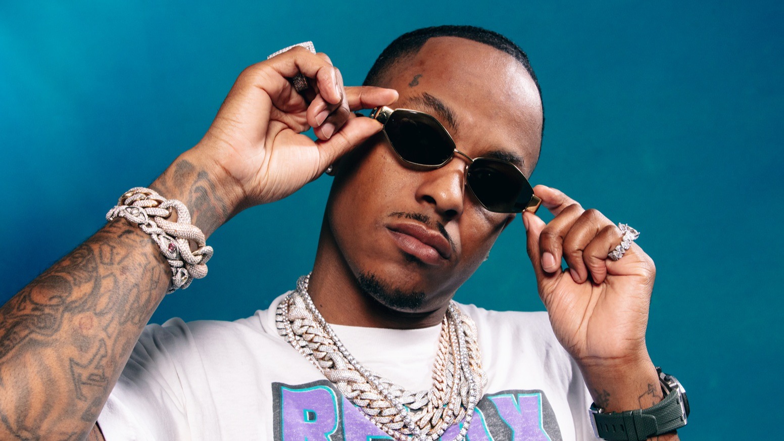 Rich The Kid tattoos: side-profile performance view of the arm tattoos
