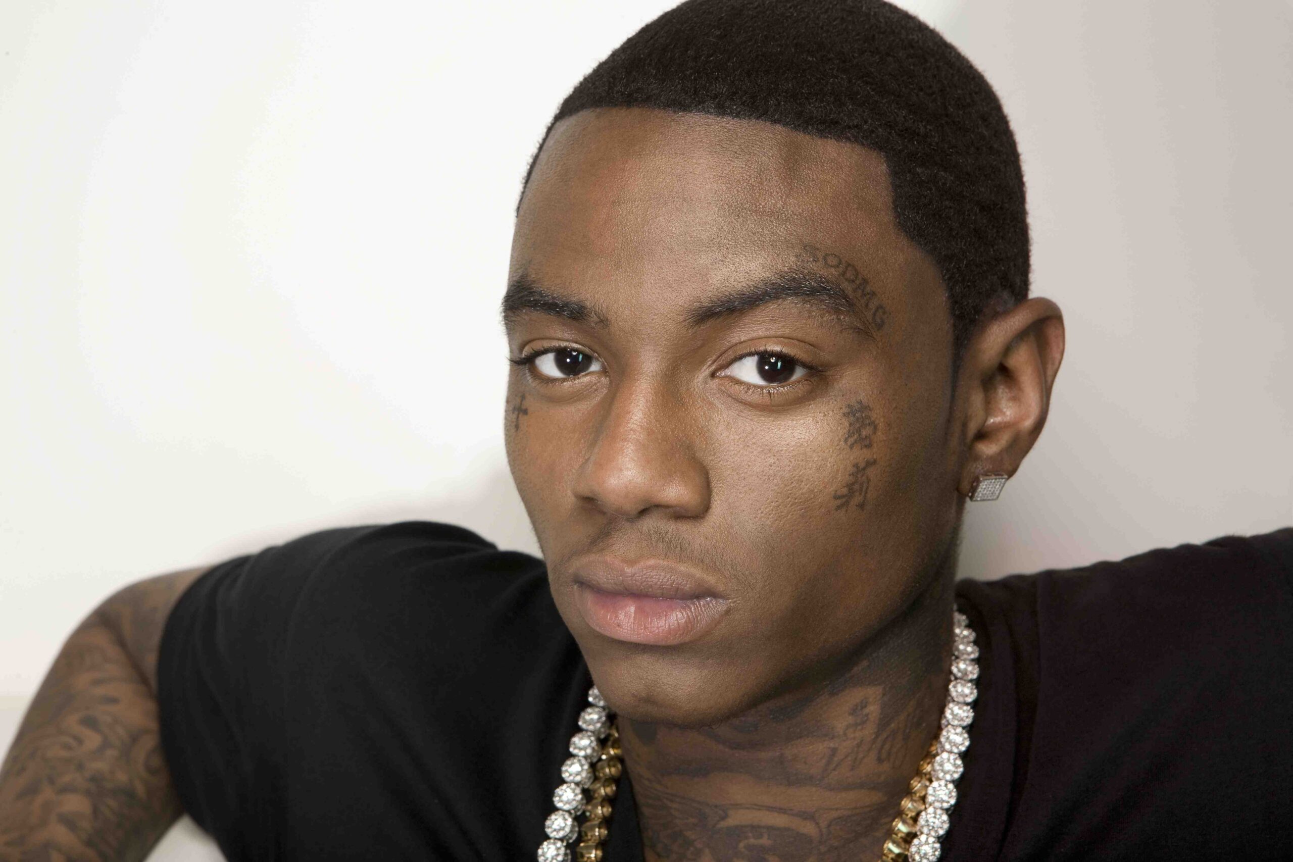 Soulja Boy tattoos: large face-visible portrait showing eyebrow, cheek, neck, and hand-adjacent ink